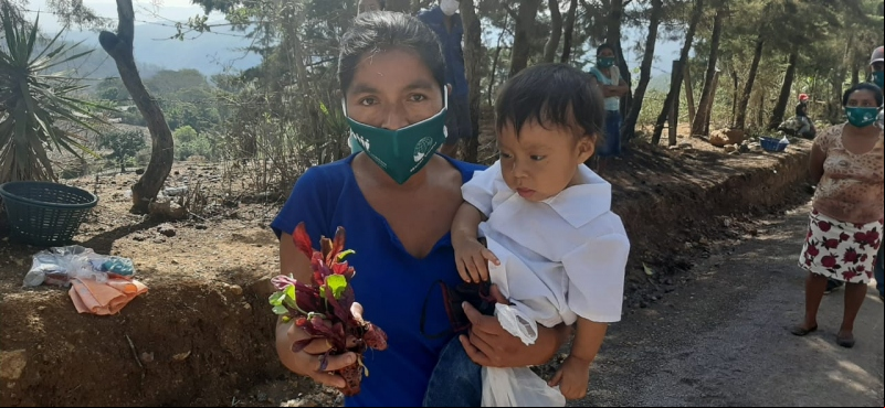 Una madre con su hijo y su mascarilla de Manos Unidas-Fundebase