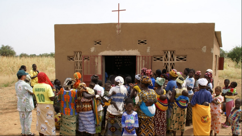 Varios personas se agolpan a la entrada de una iglesia en Burkina Faso (Javier Mármol - Manos Unidas)