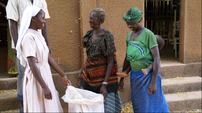 Una monja entrega una bolsa con productos de primera necesidad (Burkina Faso - Javier Mármol - Manos Unidas)