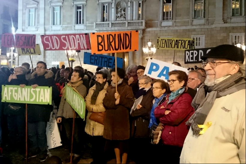Manifestantes llevan banderas con los nombres de países donde se vive en situación de guerra.