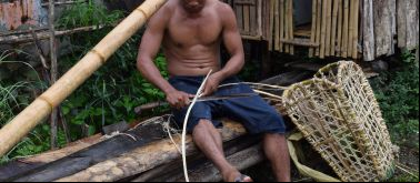 Un pescador de Filipinas elaborando una cesta de pesca.