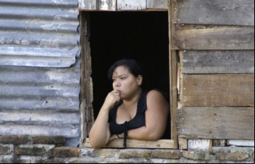 Manos Unidas - En Honduras, los activistas y los jóvenes pobres corren serio peligro - Un joven hondureña mira al horizonte desde su ventana