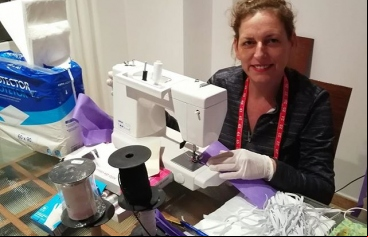 La delegada comarcal de Pego de Manos Unidas Valencia, Mónica Miralles, cosiendo material sanitario.  