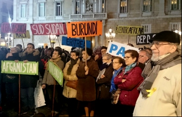 Manifestantes llevan banderas con los nombres de países donde se vive en situación de guerra.